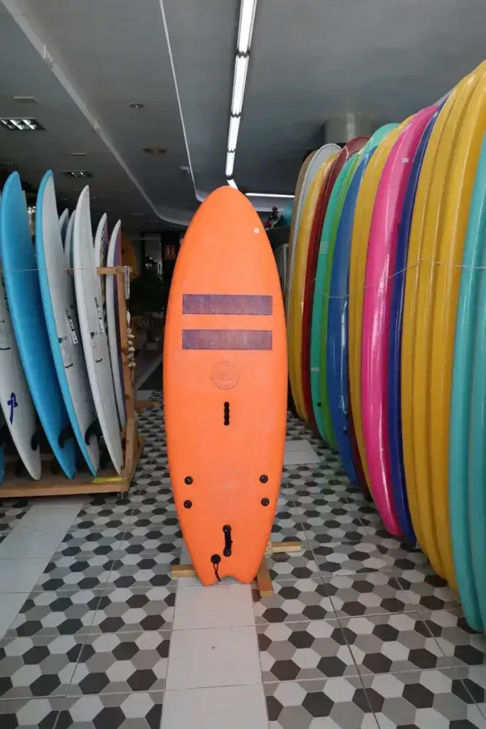 Una fila de tablas de surf están alineadas en una tienda