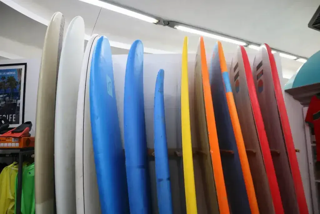 Un montón de tablas de surf están alineadas en un estante