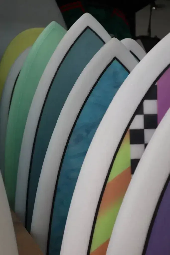 Un montón de tablas de surf están alineadas en fila