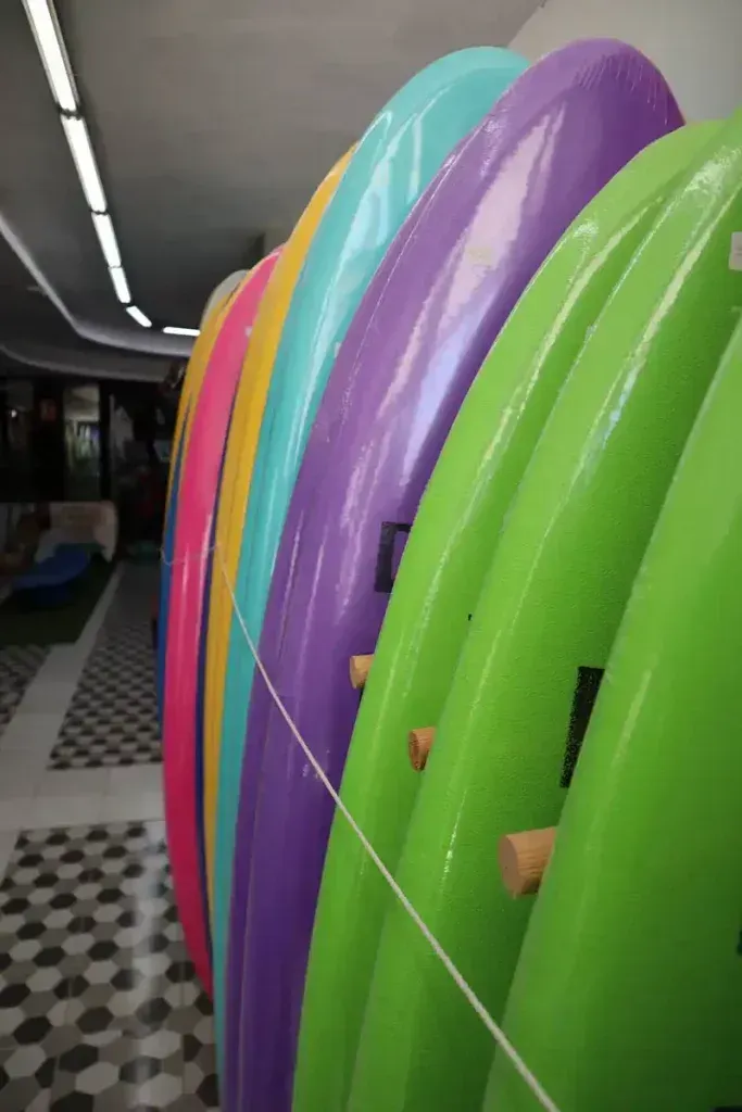 Un montón de tablas de surf están alineadas en fila