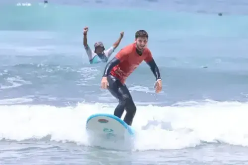 Un hombre está montando una ola en una tabla de surf en el océano.