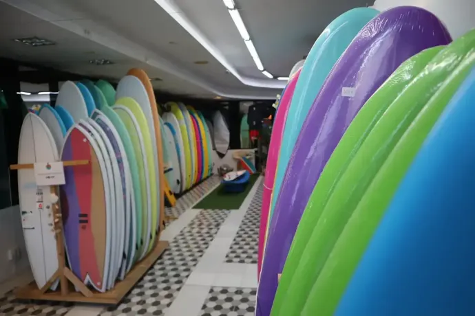 Un montón de tablas de surf están alineadas en una habitación.