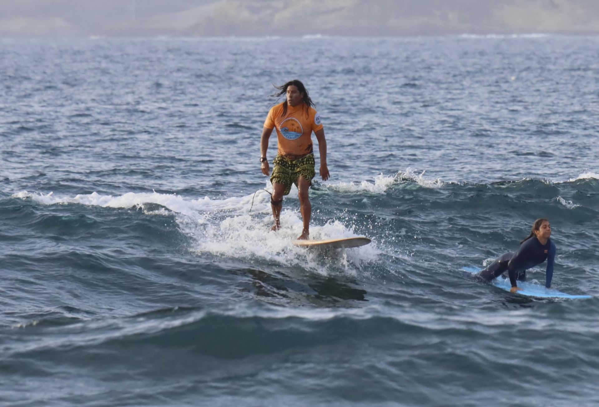 Un hombre está montando una ola en una tabla de surf en el océano.