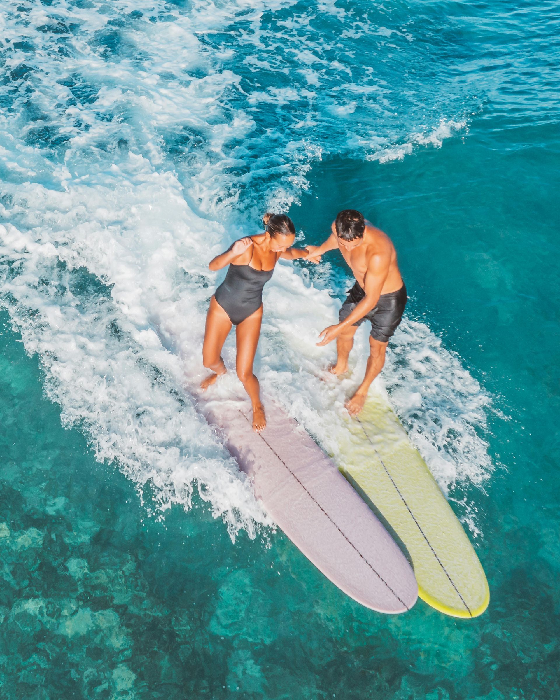 Un hombre está montando una ola en una tabla de surf en el océano.