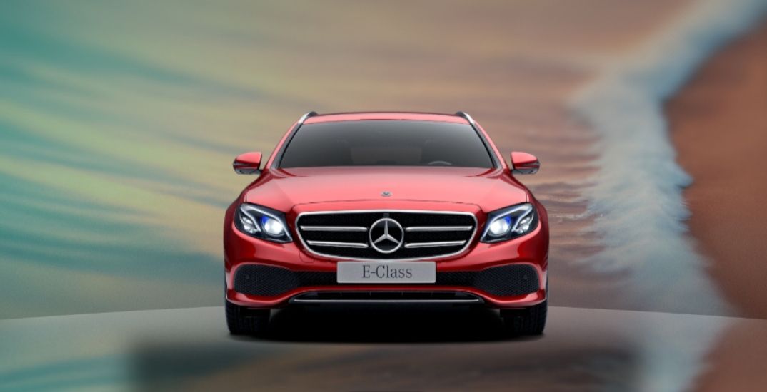 Ein roter Mercedes-Benz fährt bei Sonnenuntergang auf einer verschwommenen Straße auf die Kamera zu.