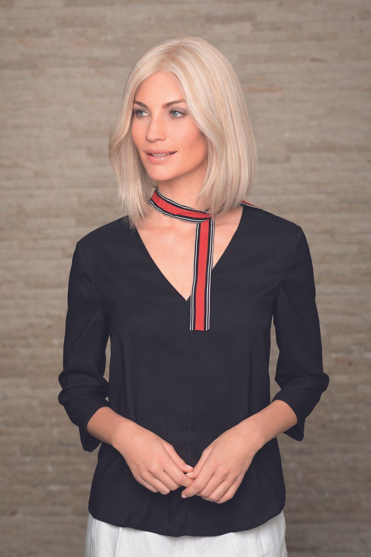 Une femme avec un carré blond et un foulard rouge