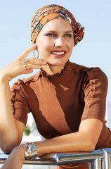 Une femme avec un turban coloré et un pull brun