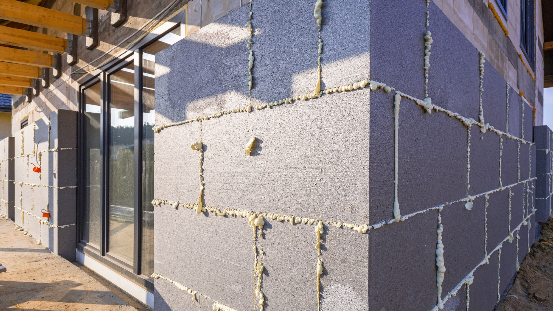 Construction des murs extérieurs d'un bâtiment à l'aide de blocs de béton isolés gris.
