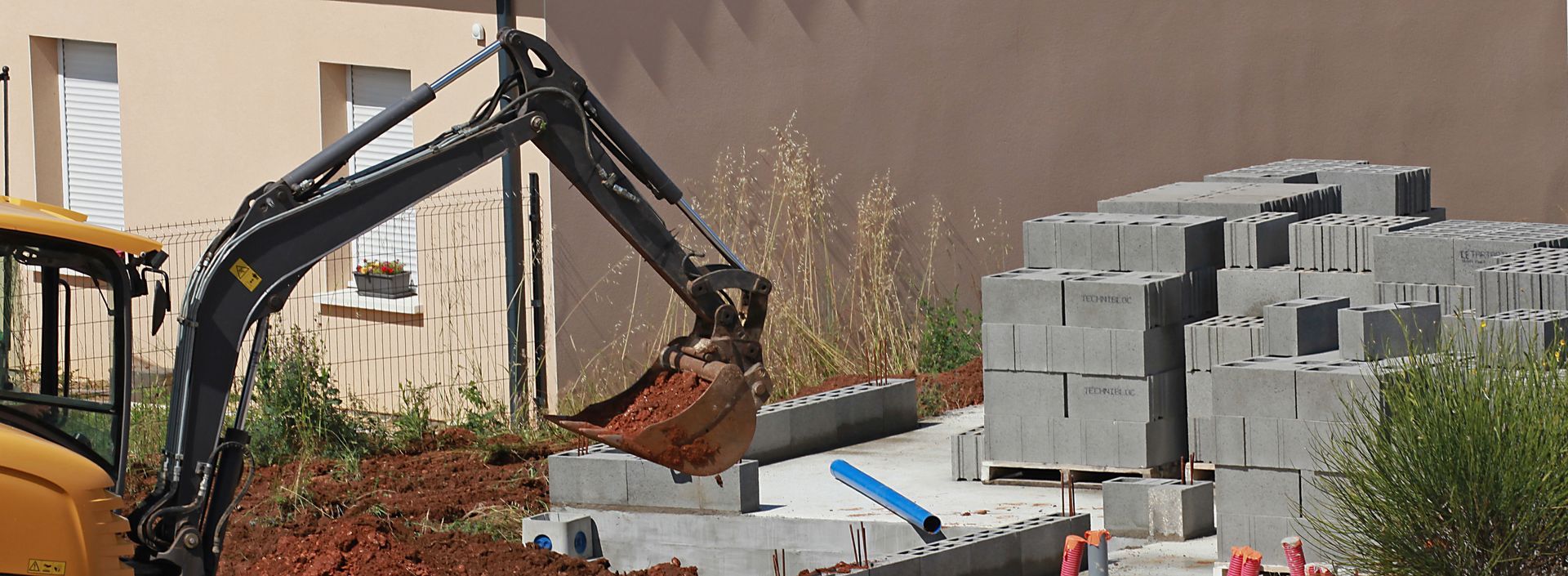 Une excavatrice extrait de la terre sur un chantier de construction.