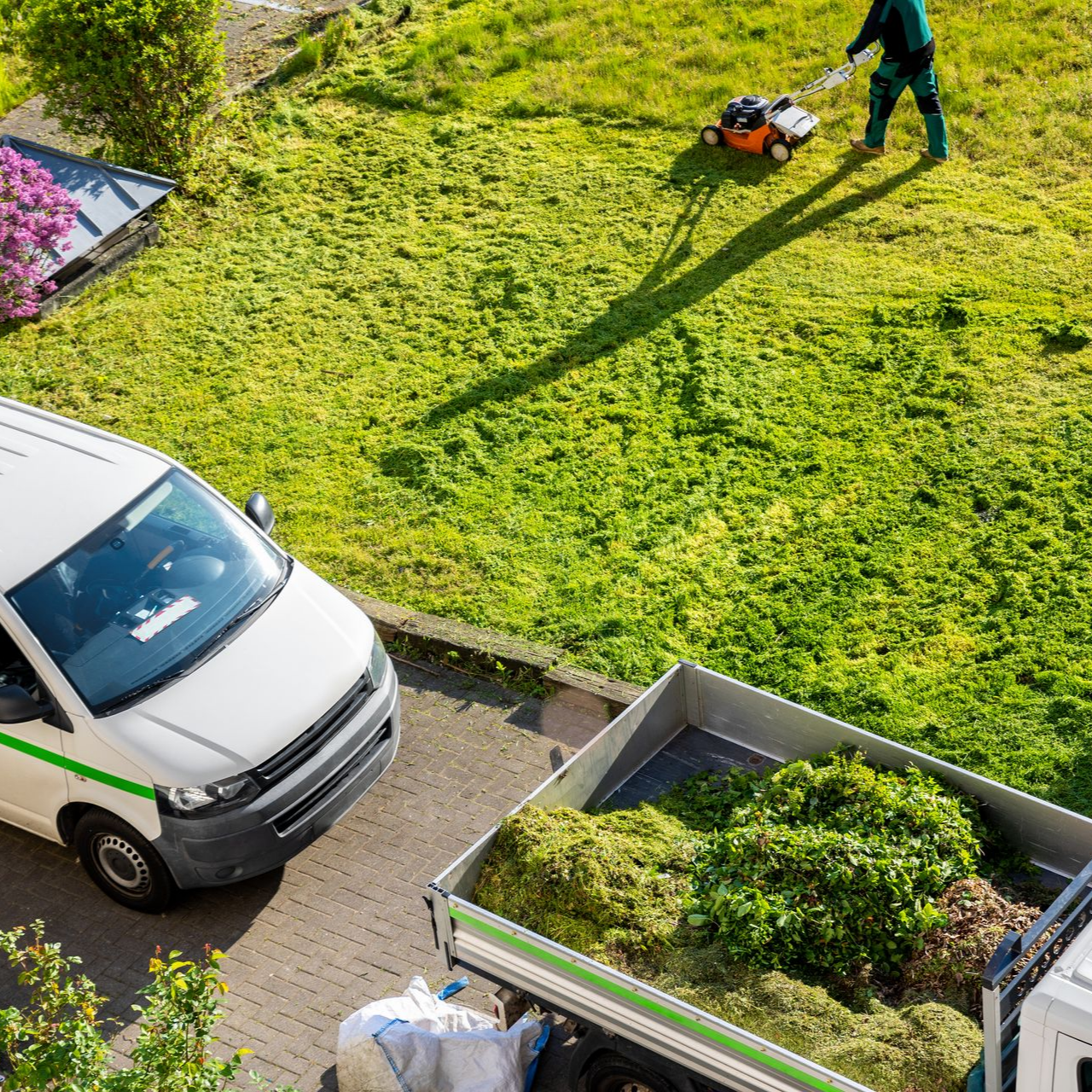 Un employé d'entretien des espaces verts tond une pelouse.