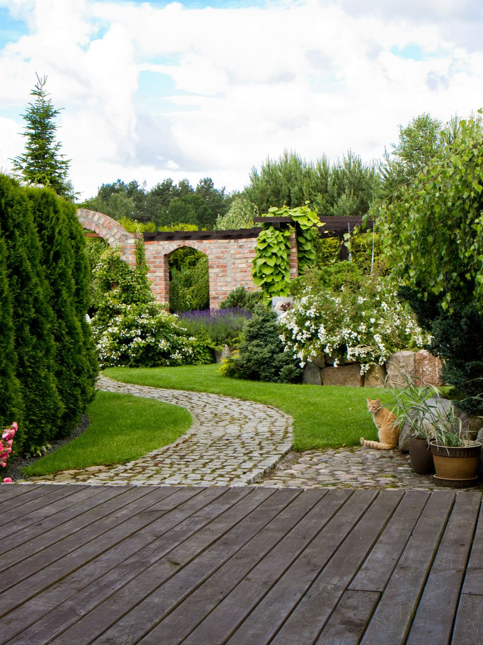 Un chemin de pierre serpente à travers un jardin luxuriant.