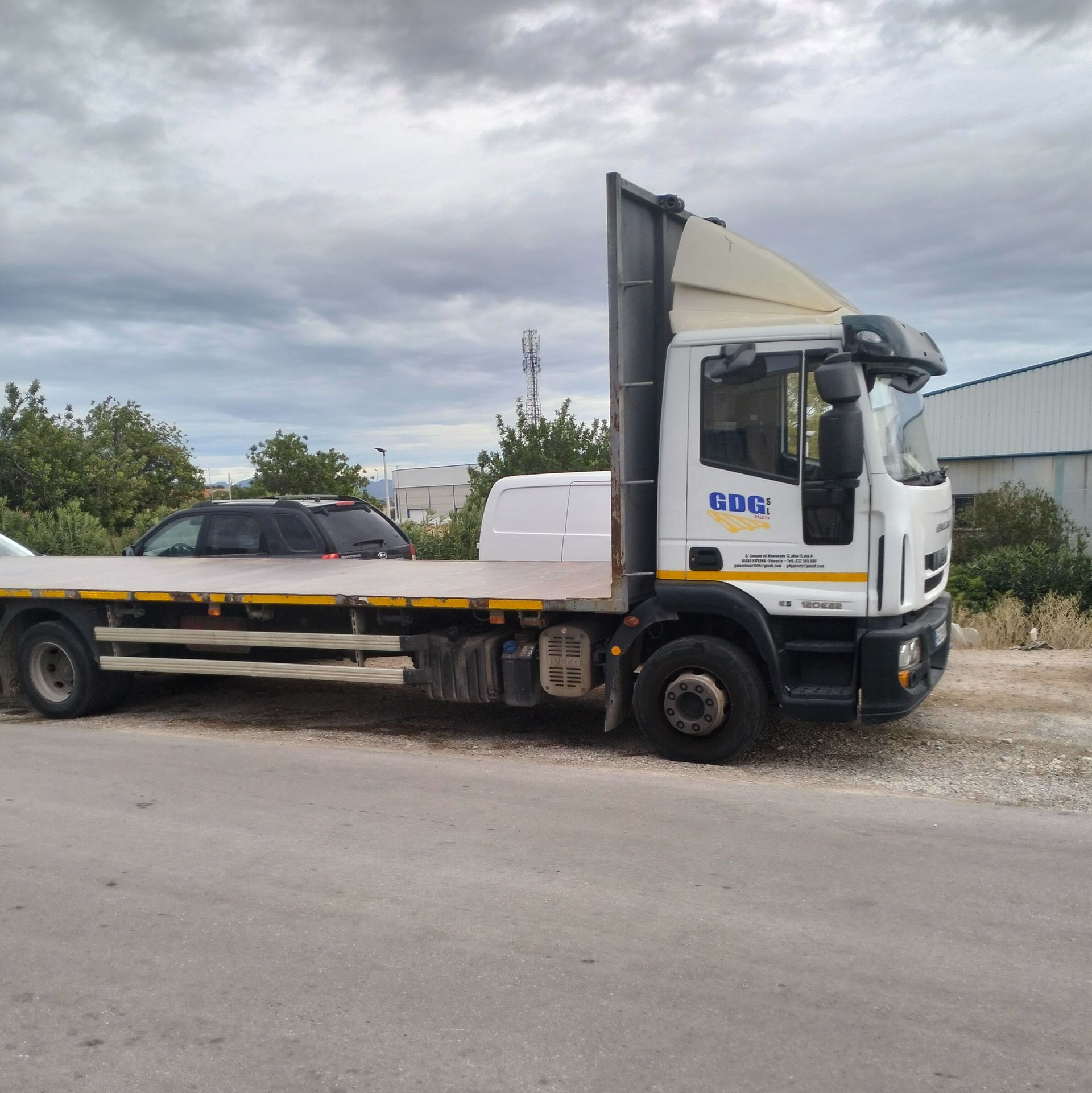 Un camión de plataforma está estacionado al costado de la carretera