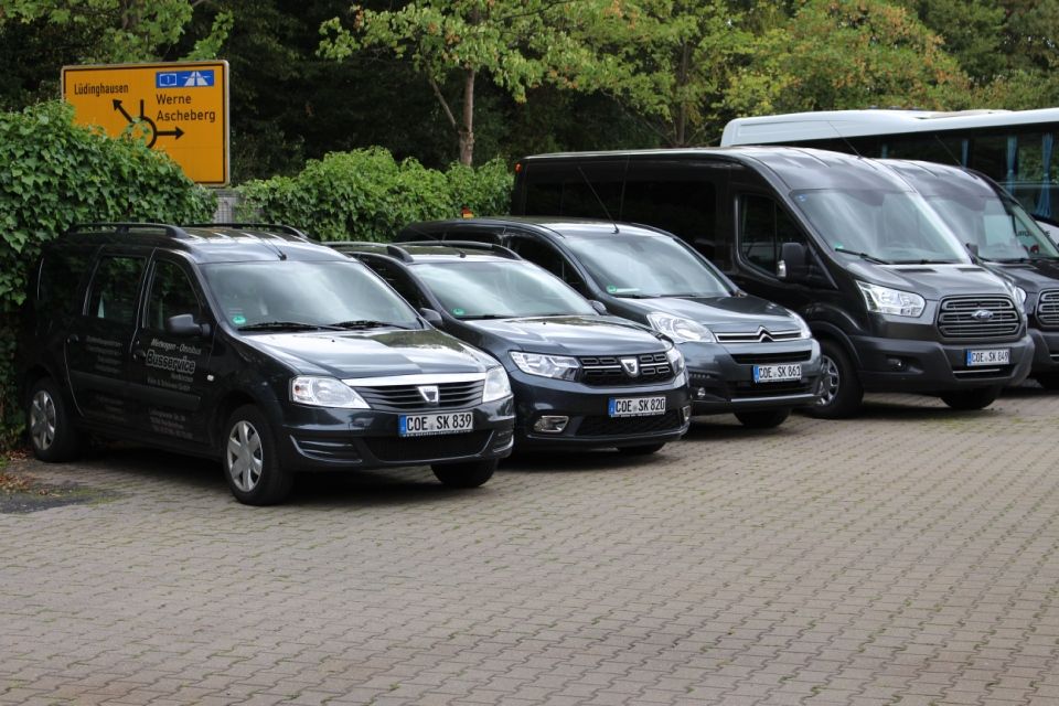 3 schwarze PKW in einer Reihe geparkt, daneben ein schwarzer Transporter