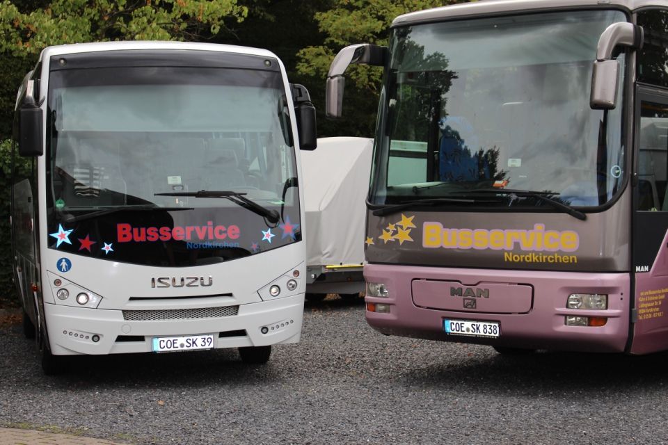 1 großer weißer Bus und ein altrosafarbener Bus