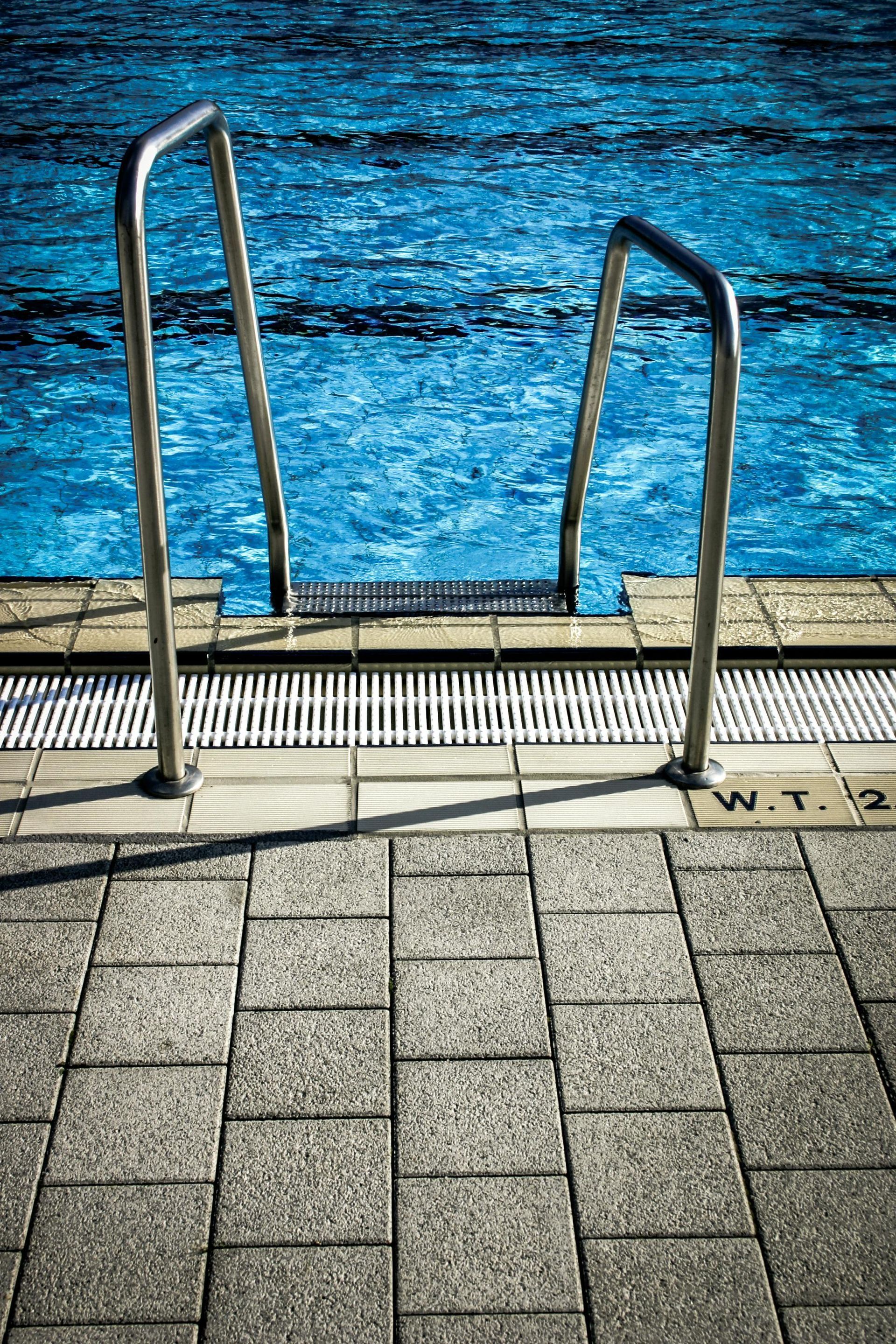 Una escalera que conduce a una piscina con agua azul.