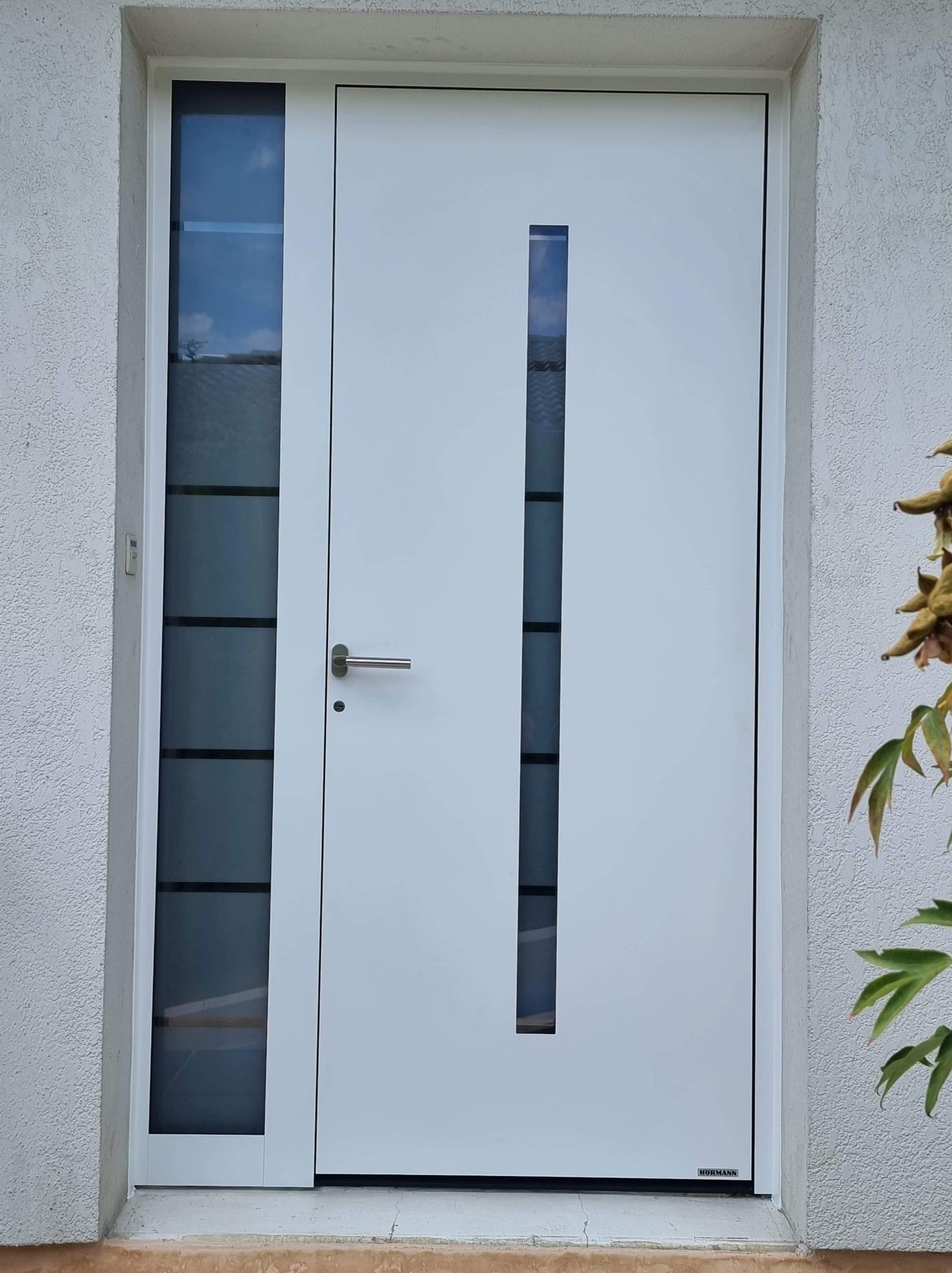 Porte d'entrée blanche avec vitres verticales