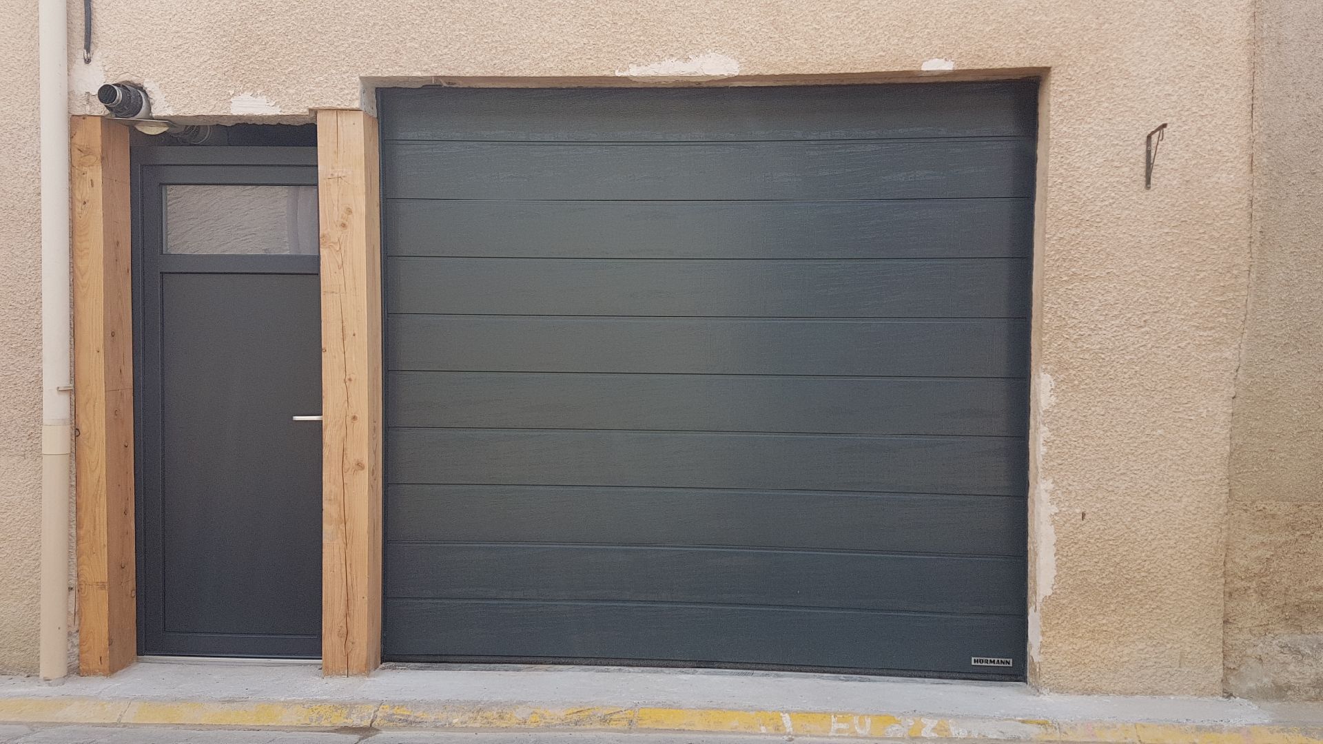 Porte sectionnelle de garage avec porte d'entrée à côté