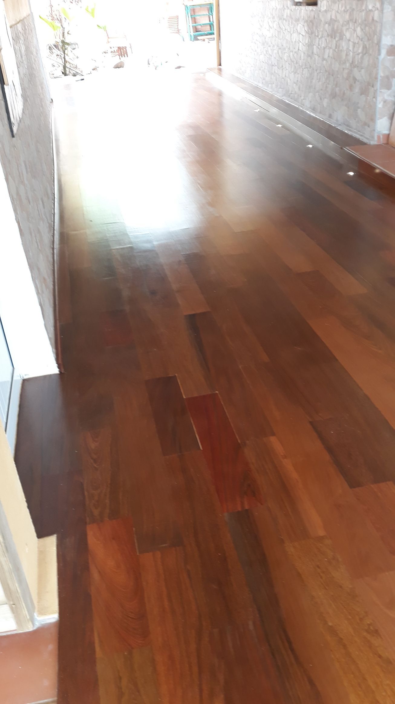 Couloir avec un parquet ciré et une lumière vive qui s’y reflète