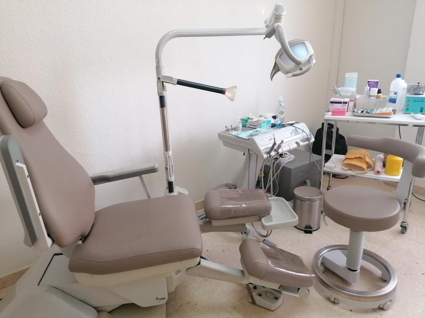 Un consultorio dental con una silla y una lámpara.