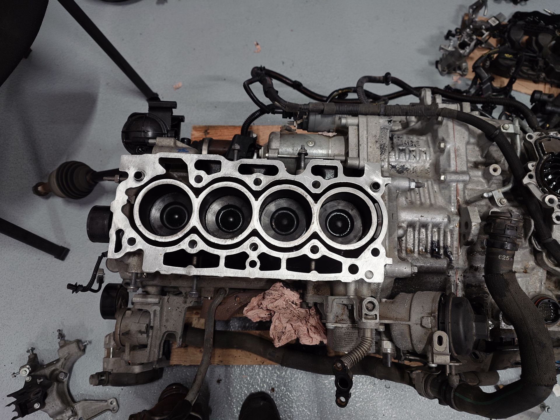 Bloc moteur à quatre cylindres ouverts, partiellement démonté en atelier.