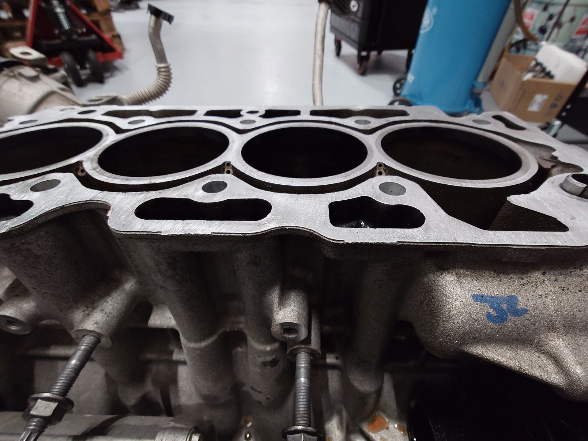 Culasse de moteur avec alésages de cylindre ouverts et filetages de boulons visibles.