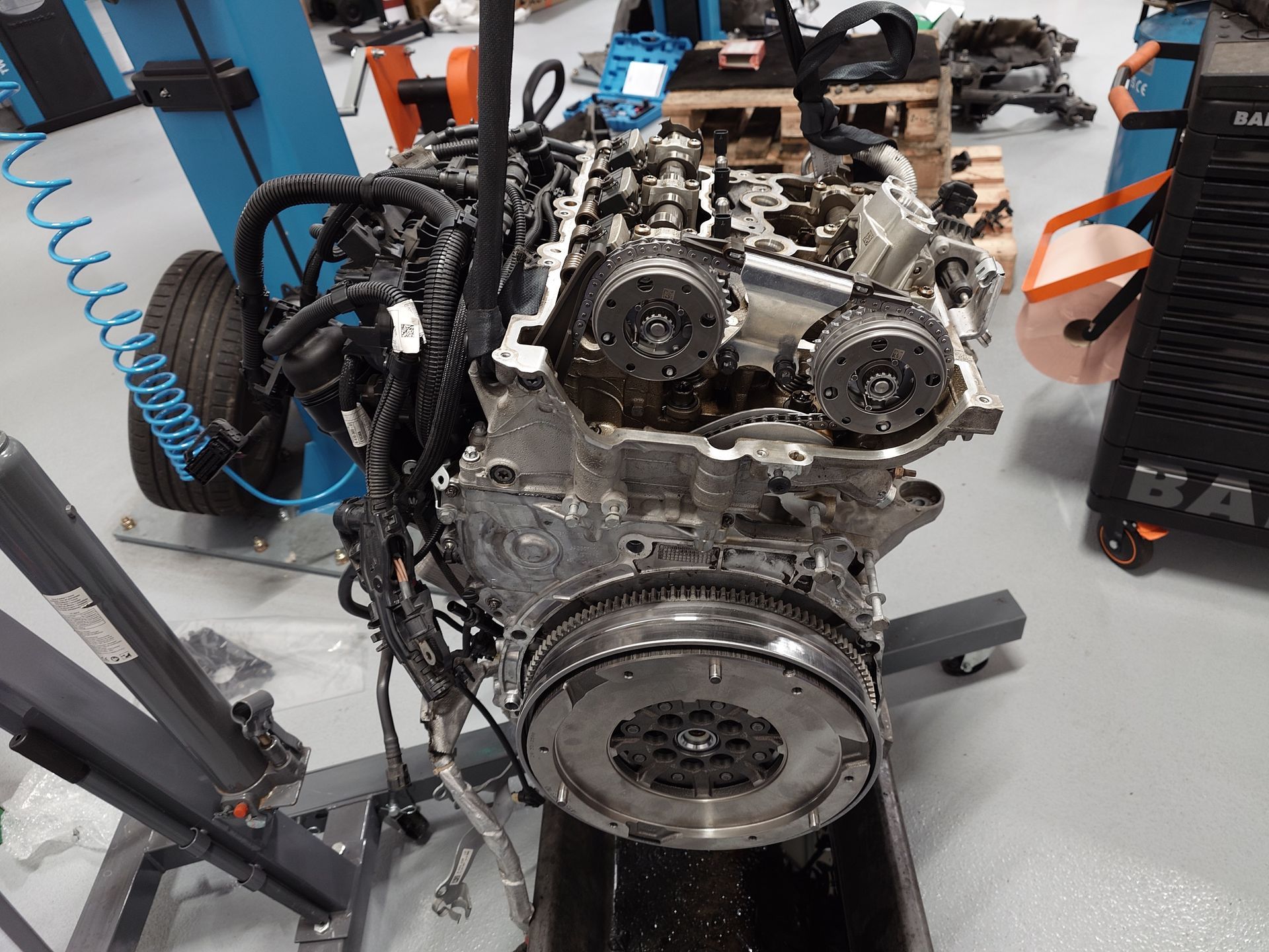 Moteur de voiture sur un support, partiellement démonté dans un atelier.