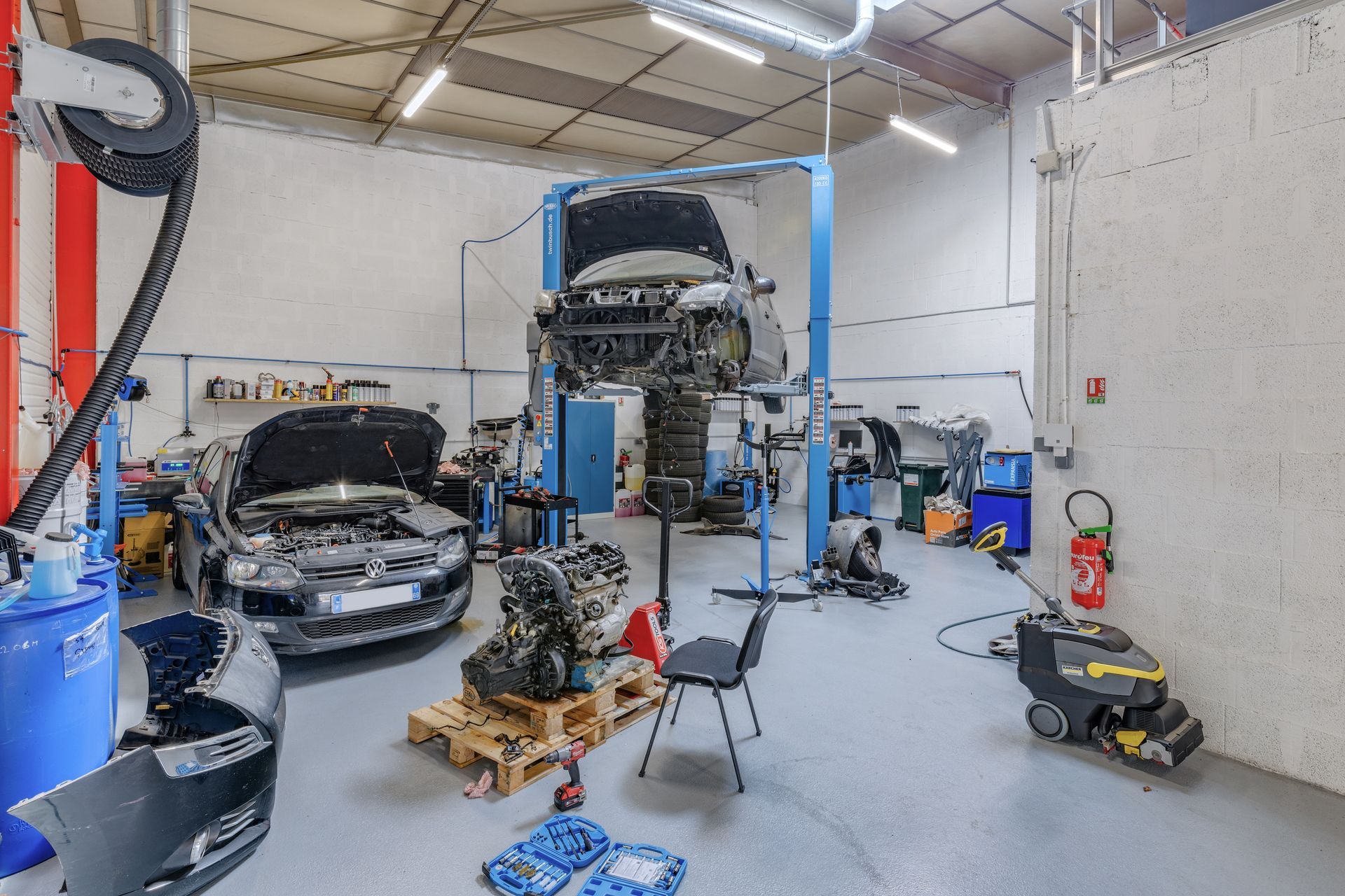 Intérieur d'un garage automobile avec deux véhicules en réparation
