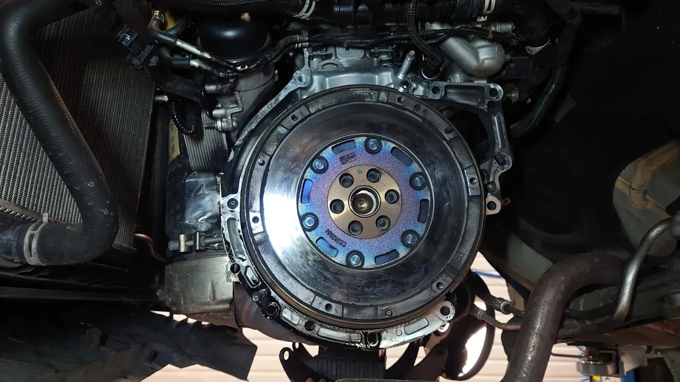 Gros plan sur un volant moteur bleu et des composants mécaniques apparents