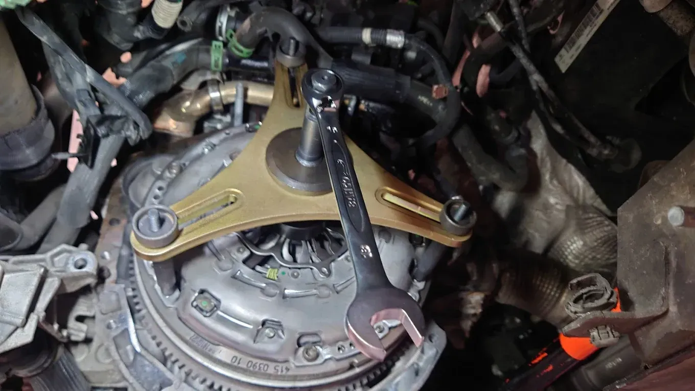 Gros plan sur le compartiment moteur d'une voiture avec une pièce de moteur dorée et des composants mécaniques exposés