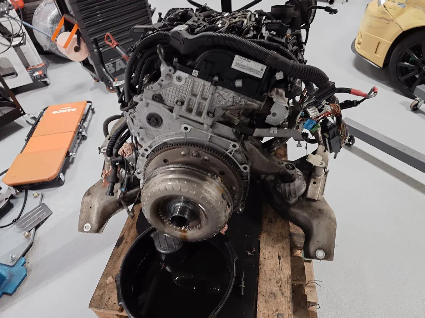 Moteur de voiture sur une palette, les fluides s'écoulant dans un bac noir