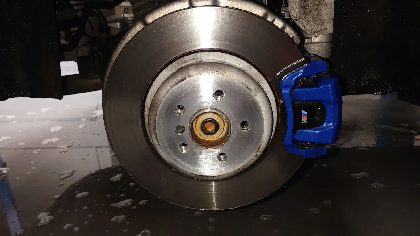 Gros plan sur un disque de frein et un étrier bleu