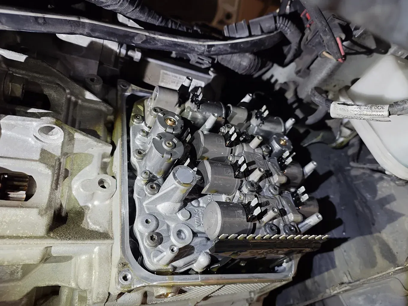 Gros plan sur une culasse de moteur exposée, avec soupapes et composants métalliques, en cours de réparation