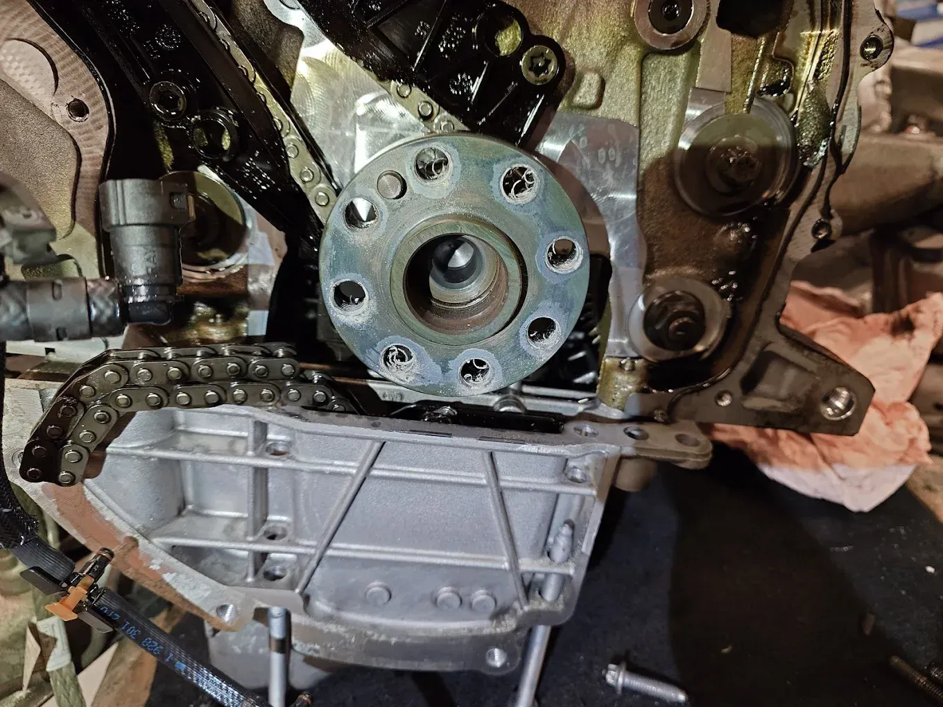 Gros plan sur un bloc-moteur laissant apparaître les composants de distribution et un carter de transmission argenté