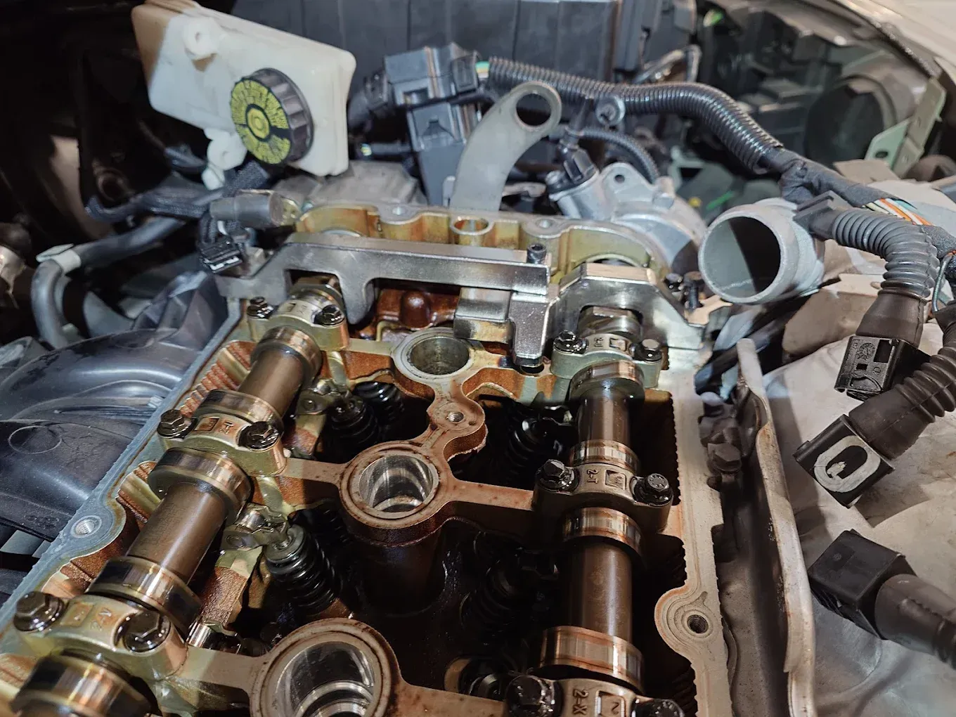 Culasse de moteur avec arbres à cames et soupapes apparents, lors d'une réparation dans un atelier automobile