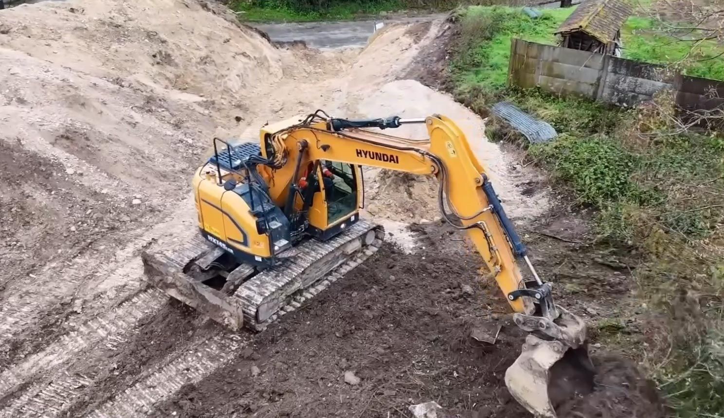 Pelleteuse de marque Hyundai jaune en train de déblayer un terrain
