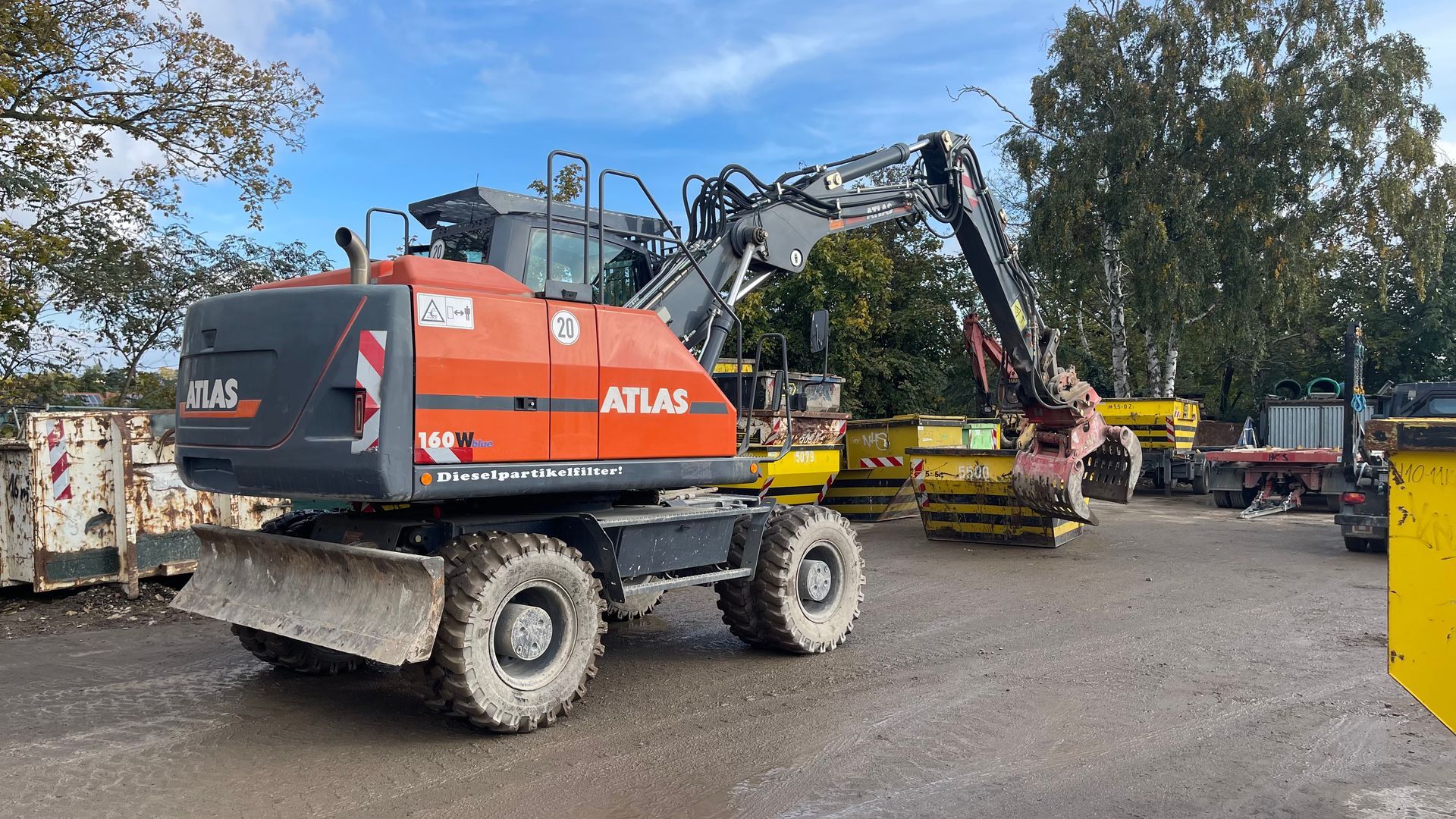 Atlas Bagger sortiert Container