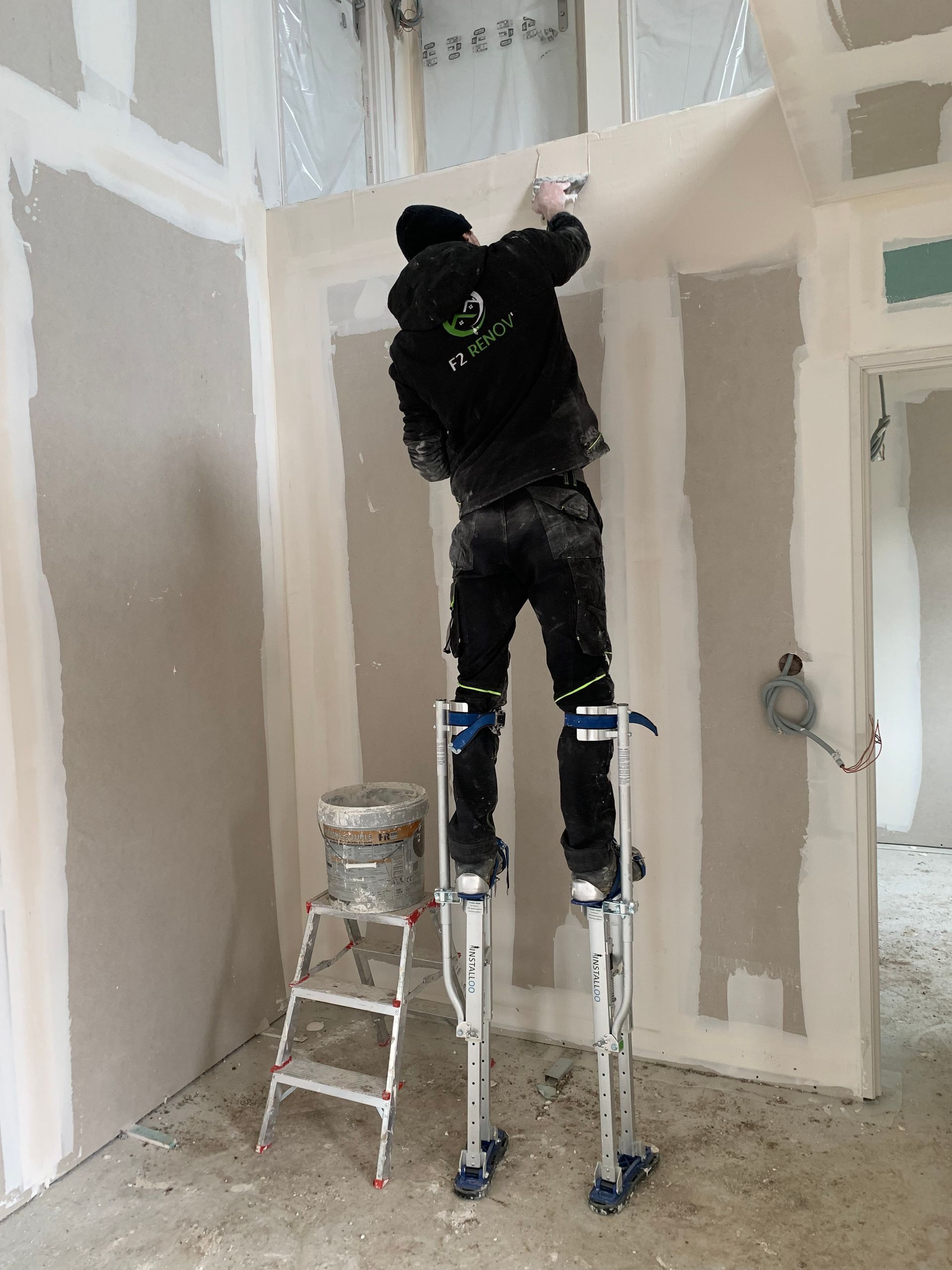 Ouvrier qui applique du plâtre sur un mur