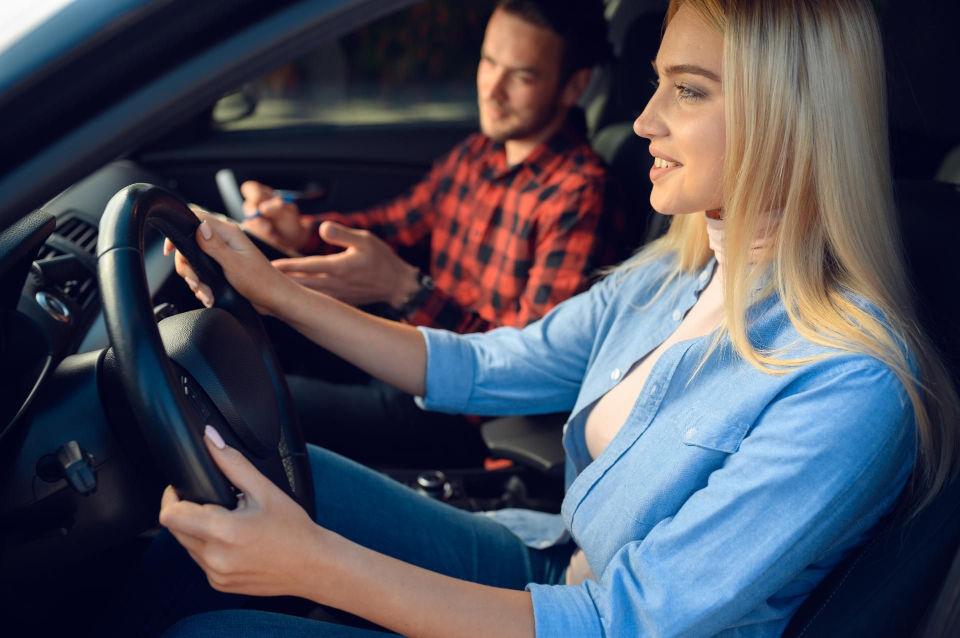 Ein Mann bringt einer Frau das Autofahren bei.
