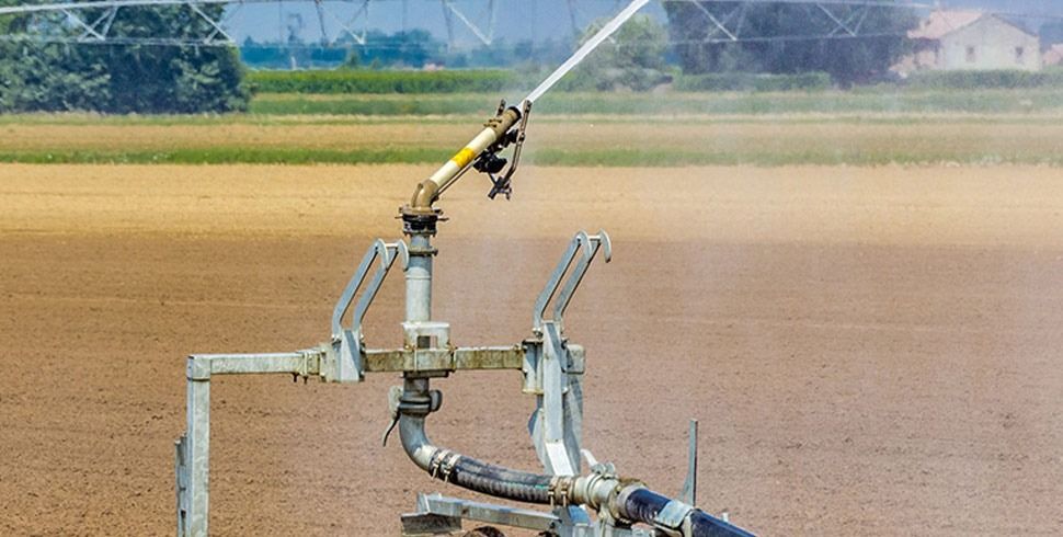 Un aspersor está rociando agua sobre un campo.
