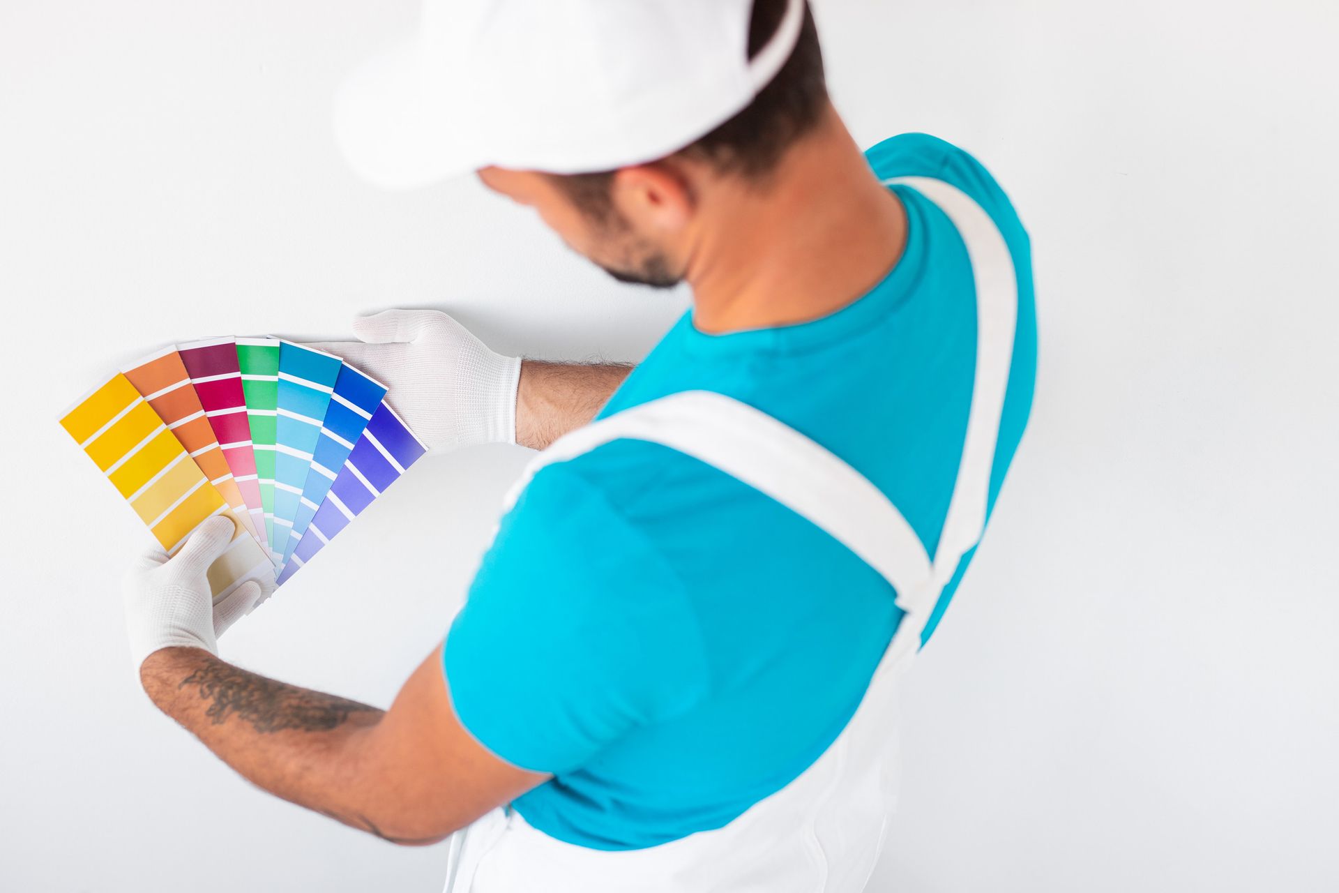 Un hombre sostiene una paleta de pintura mientras pinta una pared.