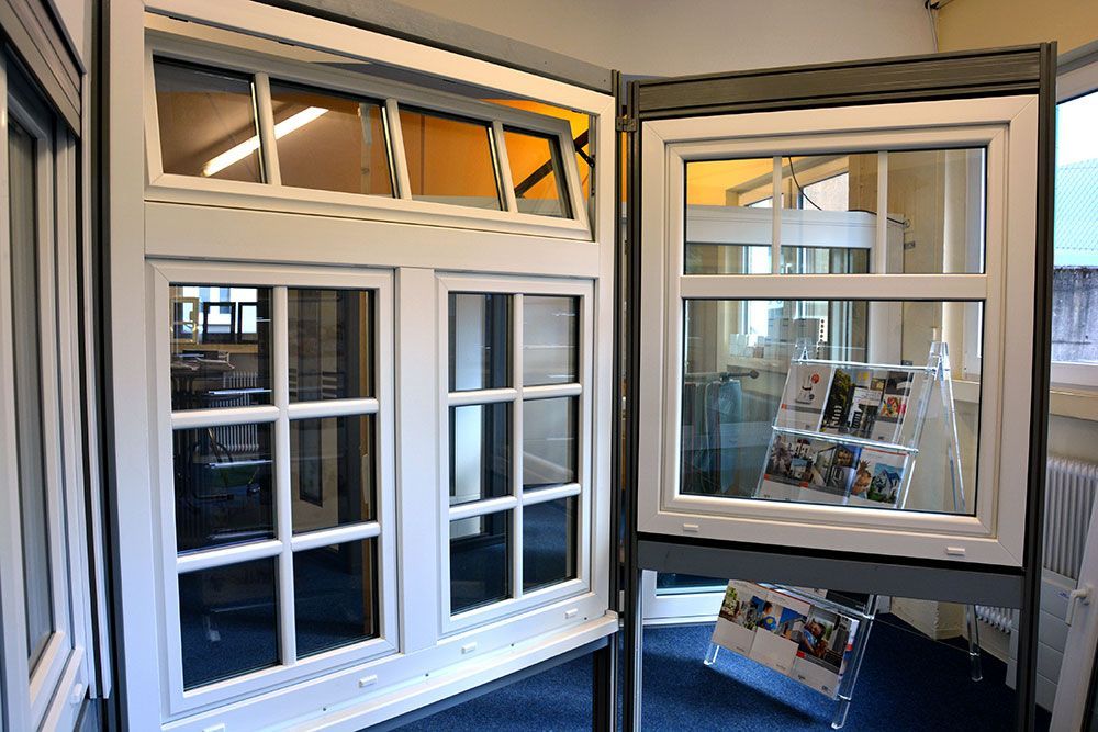 Eine Ausstellung unterschiedlicher Fenstertypen in einem Ausstellungsraum.
