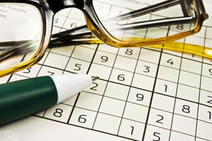 Eine Brille und ein Stift auf einem Sudoku-Puzzle