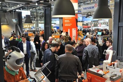 Messebesucher versammeln sich in der Nähe von Ausstellungsstücken und Ständen.