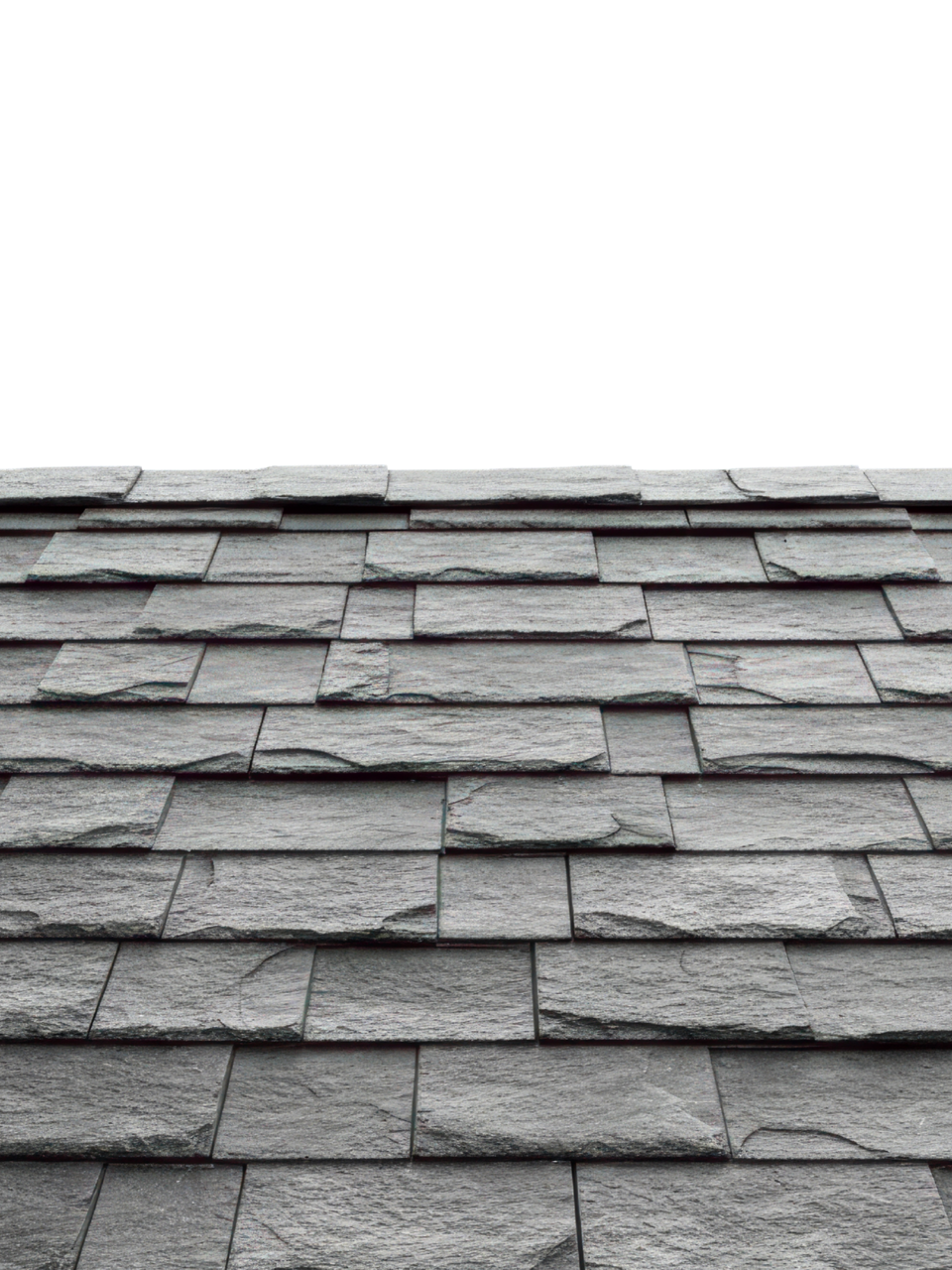 Gros plan sur un toit en ardoise, montrant des tuiles rectangulaires grises qui se chevauchent.