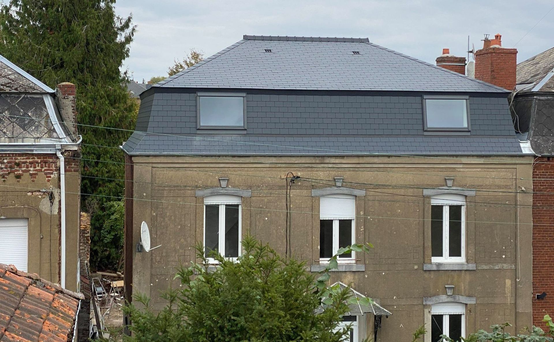 Un bâtiment avec trois fenêtres blanches.