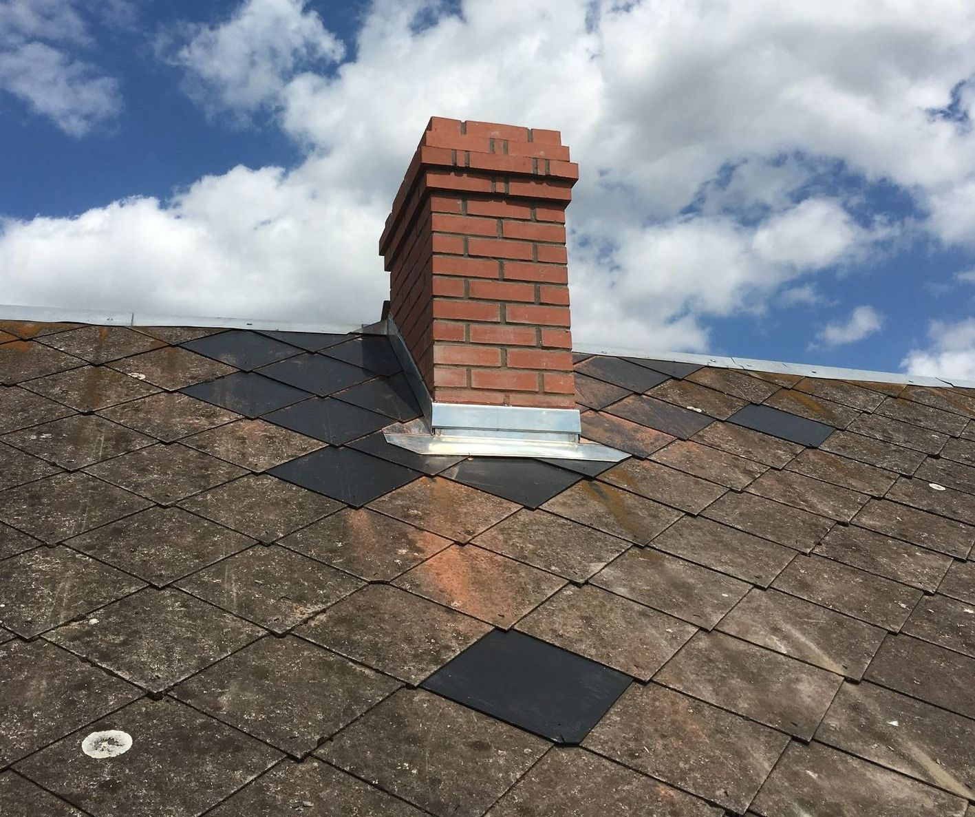 Une fenêtre de toit sur une toiture en ardoise.