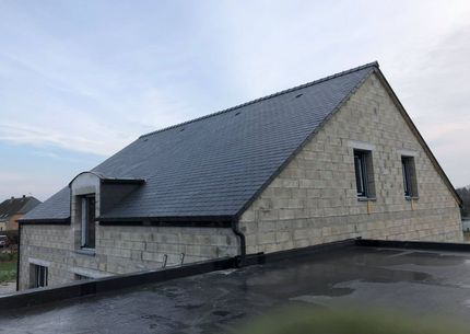 Une toiture en ardoises sur une maison en construction.