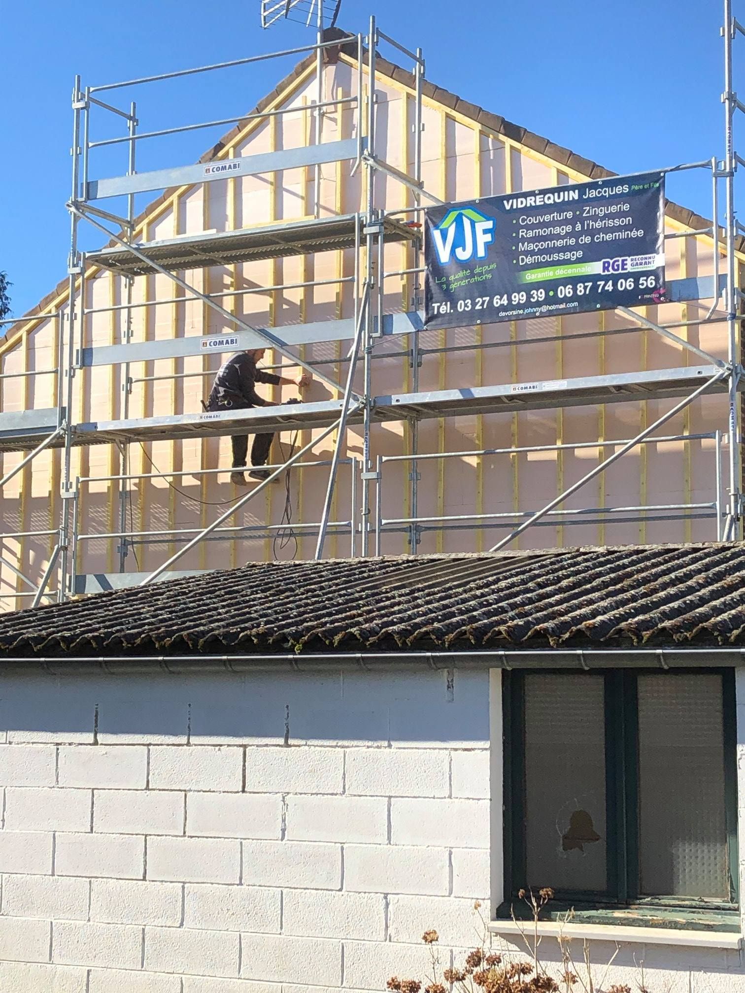 Un échafaudage devant une façade en briques.