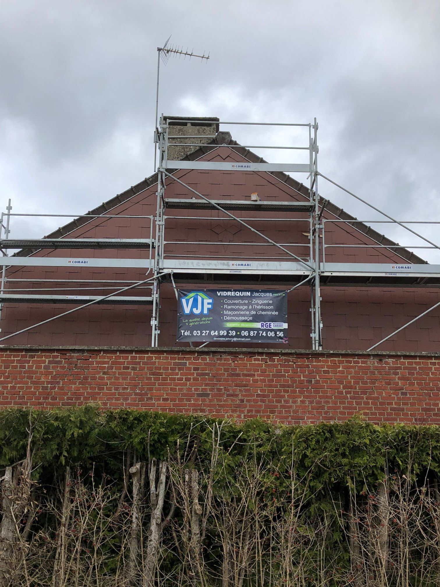 Un échafaudage devant une façade bordeaux.