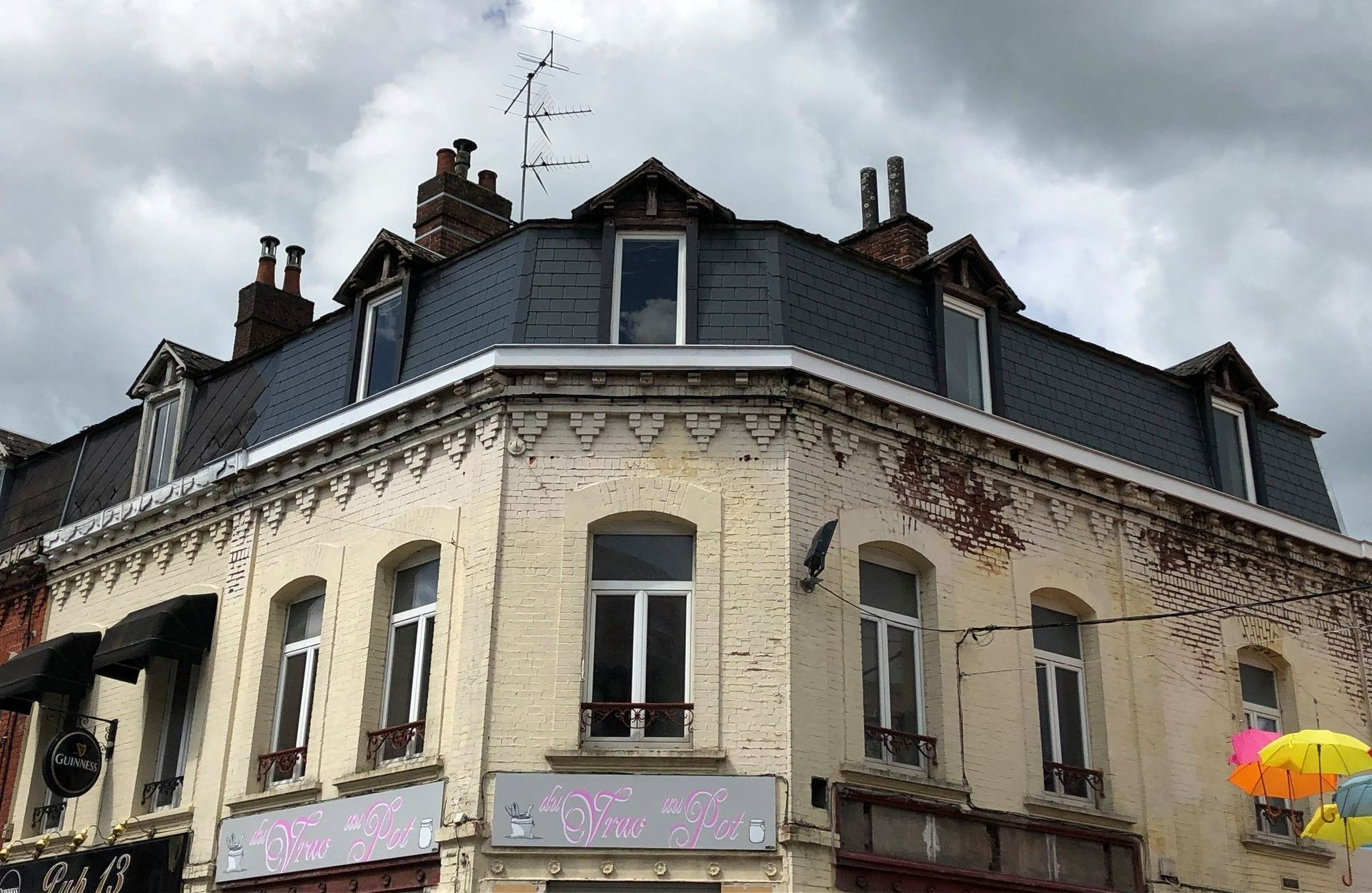 Un bâtiment avec trois fenêtres blanches.
